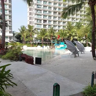 a resort with a swimming pool and a large building at Apple Paris Azure Staycation in Manila