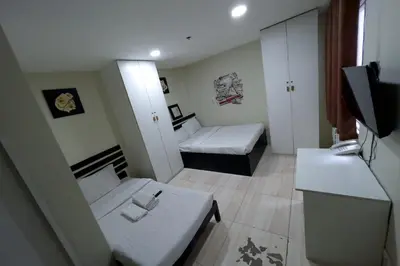 a small room with two beds and a television at Jardin Oriental Suites Ubelt Manila in Manila