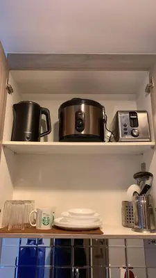 two pots and pans on shelves in a kitchen at CGS Crib staycation in Manila