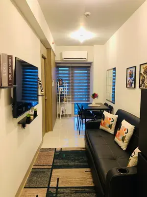a living room with a black couch and a table at CGS Crib staycation in Manila