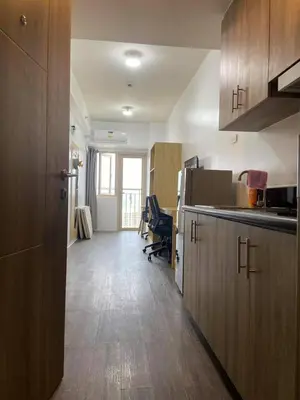 a kitchen with wooden cabinets and a desk in a room at FX Property 3926 in Manila