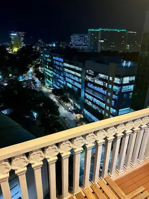a balcony with a view of a city at night at Awesome Sunset View in Venice Mall Suite with PS5 30th edition, Walk to Everything, 5 mins away to BGC, DisneyPlus, Prime Video, HBO Max in Manila