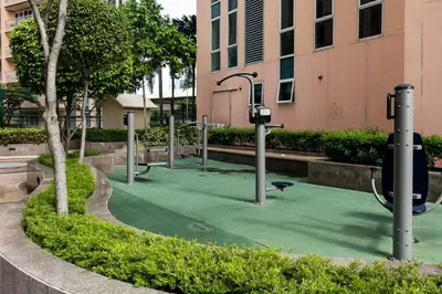 an empty park with a playground in front of a building at Awesome Sunset View in Venice Mall Suite with PS5 30th edition, Walk to Everything, 5 mins away to BGC, DisneyPlus, Prime Video, HBO Max in Manila