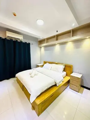 a bedroom with a large bed with a blue curtain at 1 Bedroom Seaview Room Korean Town heart of malate in Manila