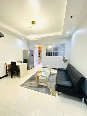 a living room with a black couch and a table at 1 Bedroom Seaview Room Korean Town heart of malate in Manila