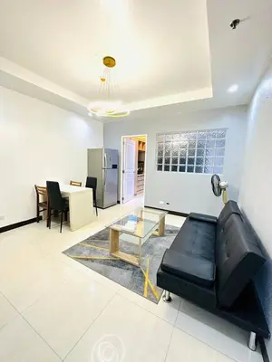 a living room with a black couch and a table at 1 Bedroom Seaview Room Korean Town heart of malate in Manila