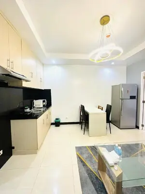 a large kitchen with a refrigerator and a table at 1 Bedroom Seaview Room Korean Town heart of malate in Manila