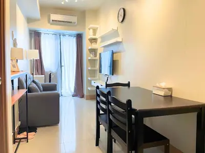 a living room with a desk with a tv and a couch at Shore Staycation at Shore 3 Mall of Asia in Manila