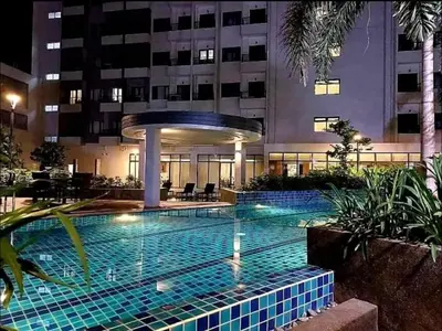 a swimming pool in front of a building at night at The Destination in Manila