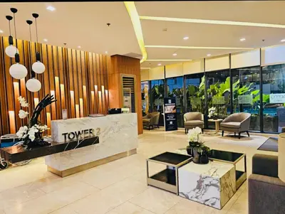 a hotel lobby with a turnover counter and chairs at The Destination in Manila