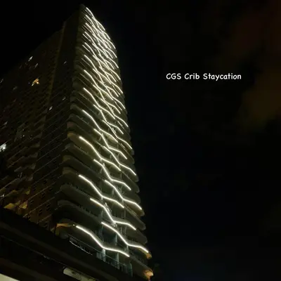a tall building with lights on it at night at CGS Crib staycation in Manila