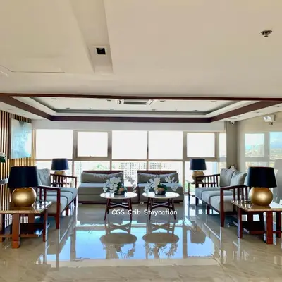 a living room with couches and tables and windows at CGS Crib staycation in Manila