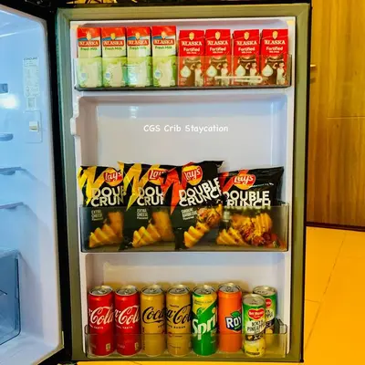 a refrigerator filled with lots of drinks and snacks at CGS Crib staycation in Manila