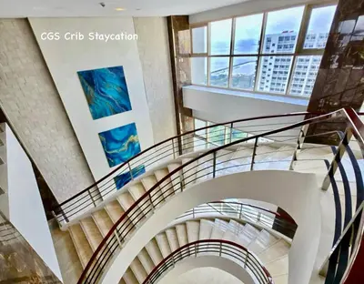 a spiral staircase in a building with windows at CGS Crib staycation in Manila