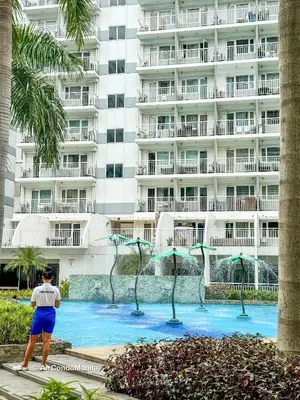 a man standing in front of a large building at 1442 Air Condo Signature Stay Modern 1BR w Balcony in Manila