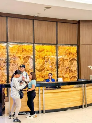 a group of people standing around a counter in a lobby at 1442 Air Condo Signature Stay Modern 1BR w Balcony in Manila