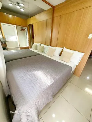 a bedroom with two beds on a boat at 1442 Air Condo Signature Stay Modern 1BR w Balcony in Manila