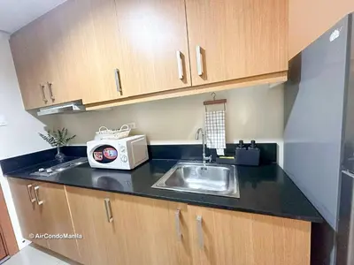 a kitchen with a sink and a microwave at 1442 Air Condo Signature Stay Modern 1BR w Balcony in Manila