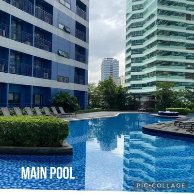 a swimming pool in front of a tall building at Modern Chic Condo at Makati with WiFi and Netflix in Manila