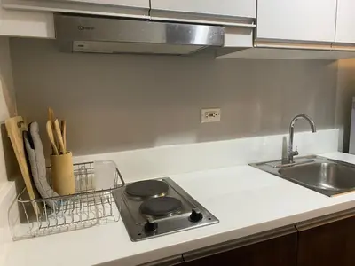 a kitchen counter with a sink and a stove at Modern Chic Condo at Makati with WiFi and Netflix in Manila