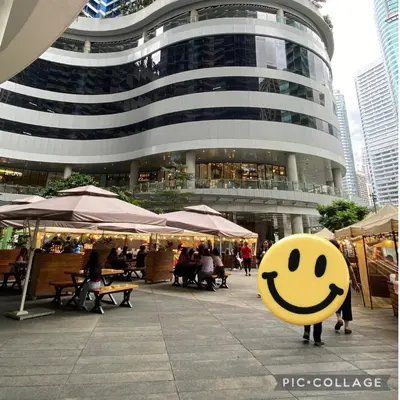 a person with a smiley face sign in front of a building at Modern Chic Condo at Makati with WiFi and Netflix in Manila