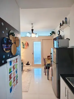 a kitchen with a refrigerator and a table at Staycationsite at Sea Residences in Manila