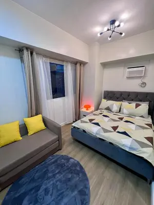 a bedroom with a bed and a couch at High and Cozy in Manila