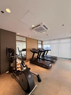 a gym with several treadmills and elliptical machines at High and Cozy in Manila