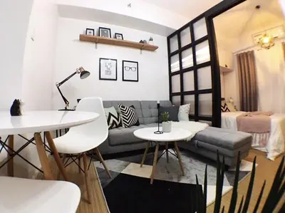 a living room with a couch and a table at Airy condo w balcony, Netflix, 3 pools, sleeps 3 in Manila