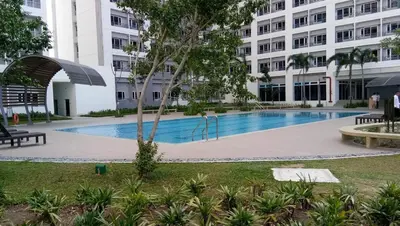 a swimming pool in front of a building at Airy condo w balcony, Netflix, 3 pools, sleeps 3 in Manila
