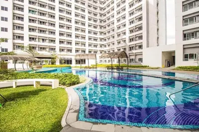 a large swimming pool in front of a building at Airy condo w balcony, Netflix, 3 pools, sleeps 3 in Manila