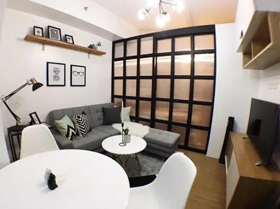 a living room with a couch and a table at Airy condo w balcony, Netflix, 3 pools, sleeps 3 in Manila