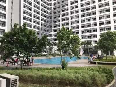 a large apartment building with a large swimming pool at Airy condo w balcony, Netflix, 3 pools, sleeps 3 in Manila