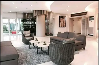 a living room with a couch and chairs and a table at Airy condo w balcony, Netflix, 3 pools, sleeps 3 in Manila