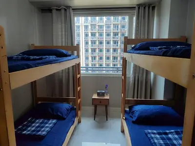 a room with three bunk beds and a window at WS906 Condo near Moa, Free Pool Access in Manila