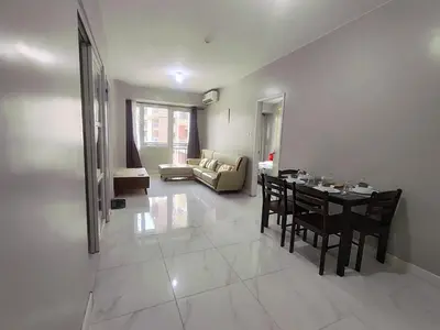 a living room with a table and chairs and a couch at WS906 Condo near Moa, Free Pool Access in Manila