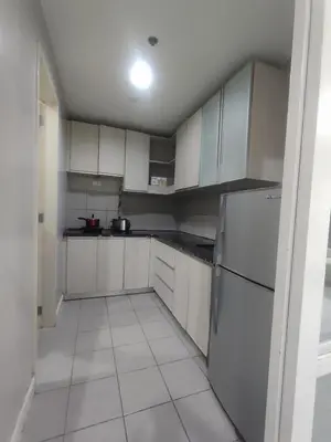 a kitchen with white cabinets and a white tile floor at WS906 Condo near Moa, Free Pool Access in Manila