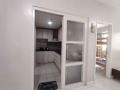 a kitchen with white cabinets and a large glass door at WS906 Condo near Moa, Free Pool Access in Manila