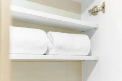 two towels are sitting on a shelf in a bathroom at Eastwood City 1BR Muji Home Luxe Minimalist Fast WiFi in Manila