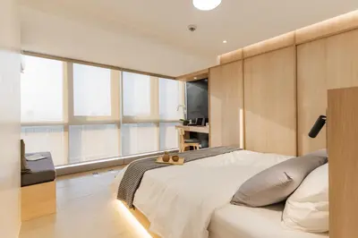 a bedroom with a large white bed and windows at Eastwood City 1BR Muji Home Luxe Minimalist Fast WiFi in Manila