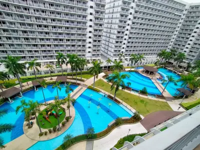 an aerial view of two pools in a resort at GV Holiday Homes - Shell Residences MOA - Cozy 1BR Apartment in Manila