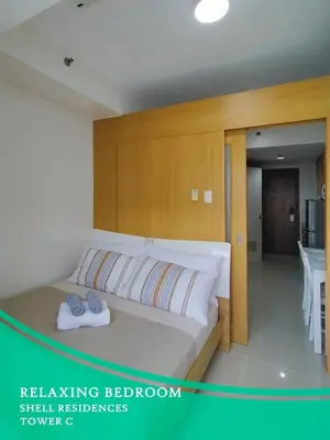 a bedroom with a bed with a sink and a tub at GV Holiday Homes - Shell Residences MOA - Cozy 1BR Apartment in Manila