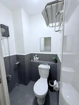 a small bathroom with a toilet and a sink at Urban Deca Towers Cubao in Manila