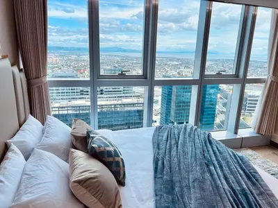 a bed in a room with a large window at Executive 5BR Penthouse Suite in Uptown BGC in Manila