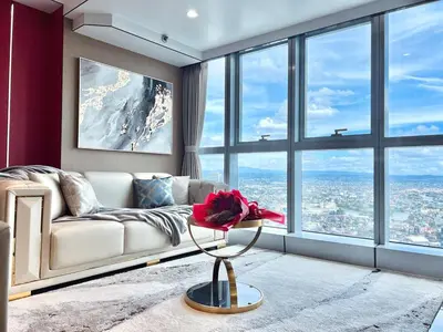 a living room with a couch and large windows at Executive 5BR Penthouse Suite in Uptown BGC in Manila