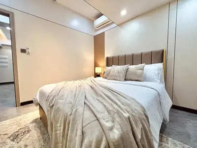 a bedroom with a large bed with white sheets and pillows at Executive 5BR Penthouse Suite in Uptown BGC in Manila