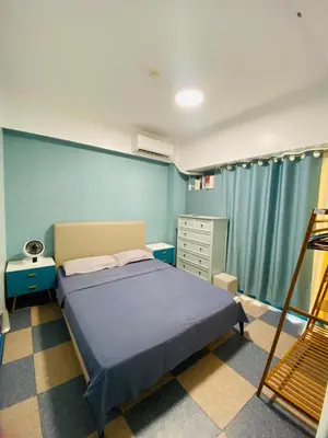a bedroom with a bed and a dresser at Torre De Manila taft Tan38 in Manila