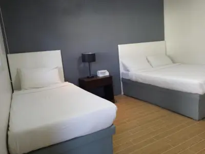 a room with two beds and a table with a lamp at The Nice rssort in General Trias