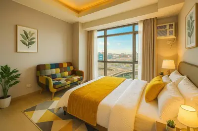 a bedroom with a large bed and a window at 1BR with Queen Bed and Balcony, Walk to Okada in Manila