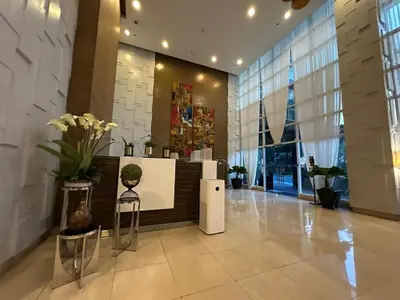 a lobby of a building with a counter with flowers at Spacious 1BR Condo with 300mbps WiFi in BGC in Manila
